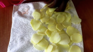 Thinly sliced potato slices getting dried on a clean towel