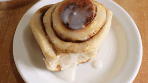 a cooked cinnamon roll drizzled with a simple lemon icing.