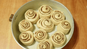 The sourdough rolls arranged in the pan have puffed up slightly.