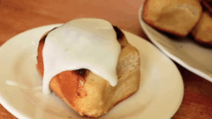 A Stovetop Sourdough Cinnamon Roll drizzled with a tangy-sweet lemon icing.