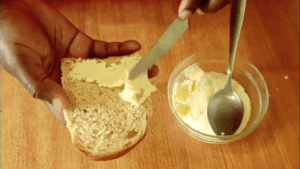 homemade cream cheese is ready and being spread on bread.