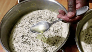 The dough surface sprinkled with finely chopped rosemary leaves and drizzled with oil.