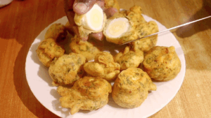Crispy egg pakora cut open to show the inside texture