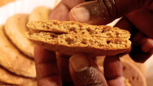 Close-up of no-oven gluten-free digestive biscuit cut open to reveal crunchy inside texture.