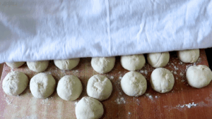 the dough divided into pieces and covered with a clean kitchen towel.