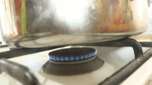 Very low stovetop flame showing the heat setting used for baking tea scones without an oven.